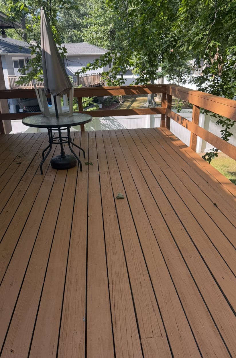 Long backyard deck after remodeling — cleaned and refinished boards with restored railing